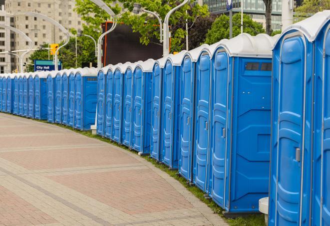 a fleet of portable restrooms ready for use at a large outdoor wedding or celebration in Clyde Hill